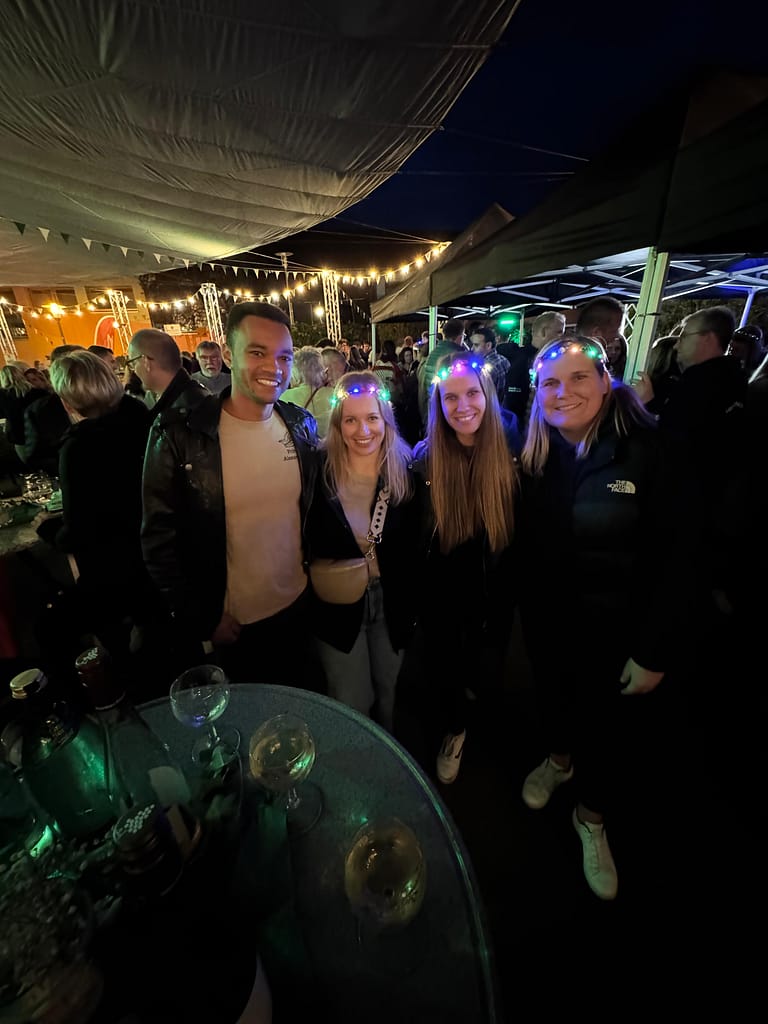 Gäste mit Leuchtkränzen feiern am Abend beim Lother Weinfest 2025